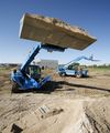 Погрузчик Genie GTH 4013 EX поднимает ковш, груженый песком